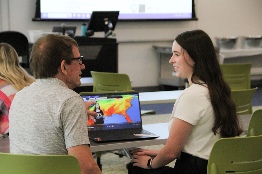 A professor and student review data on a laptop