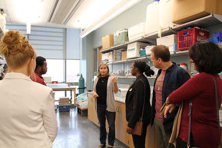 Faculty and students talking in a lab
